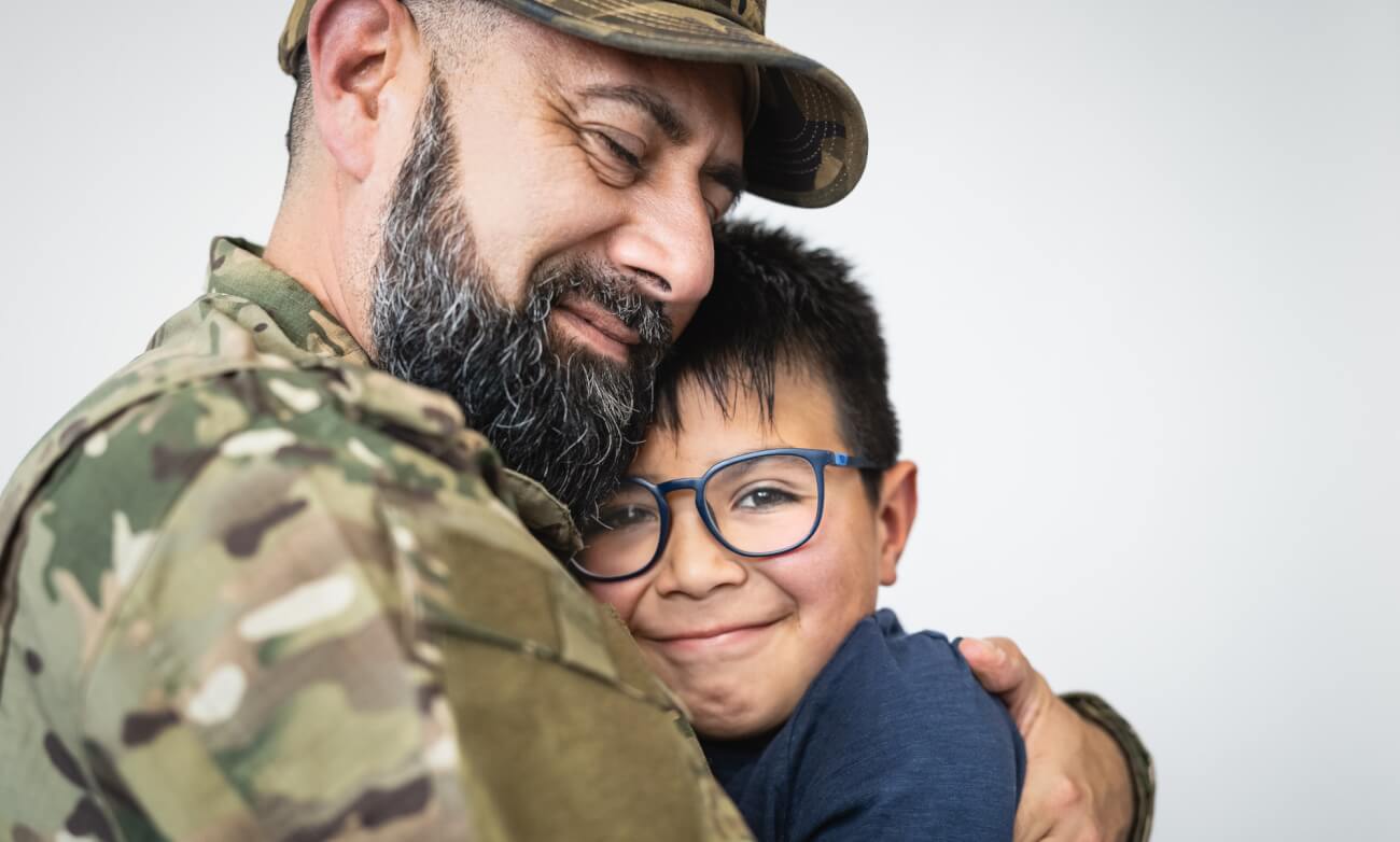 Military soldier embracing his son before leaving for the war